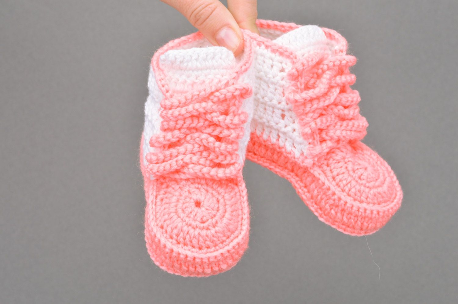 Schöne rosafarbige gehäkelte Babyschuhe mit Schuhbändern in Form der Turnschuhen foto 3