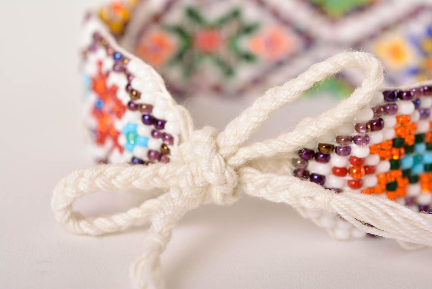 Knitted beaded white cord strand bracelet with ethnic ornament photo 4