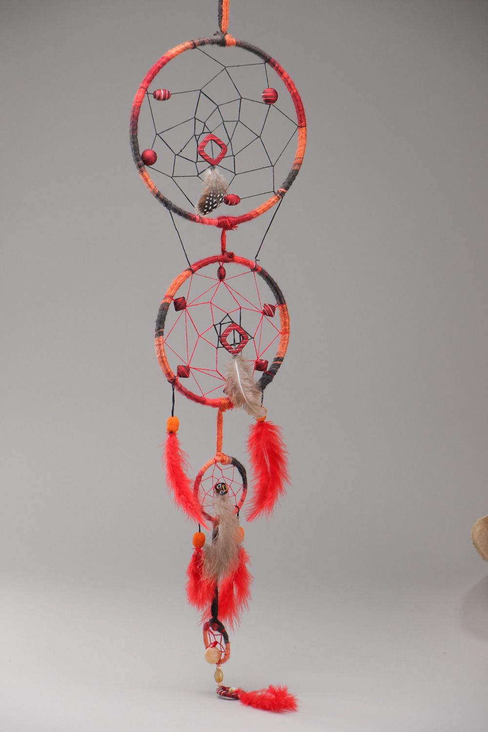 Long red homemade dreamcatcher wall hanging with natural stones and feathers photo 2