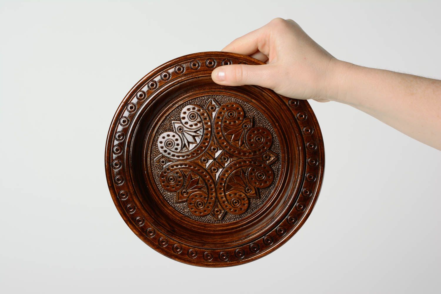 Handmade designer varnished wooden wall plate with art carving of dark color photo 3