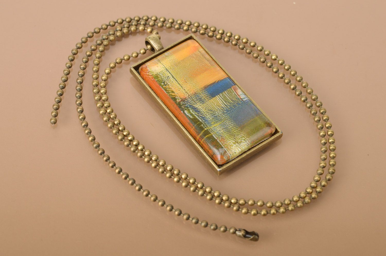 Handmade rectangular metal pendant in warm colors on long chain of bronze color  photo 2
