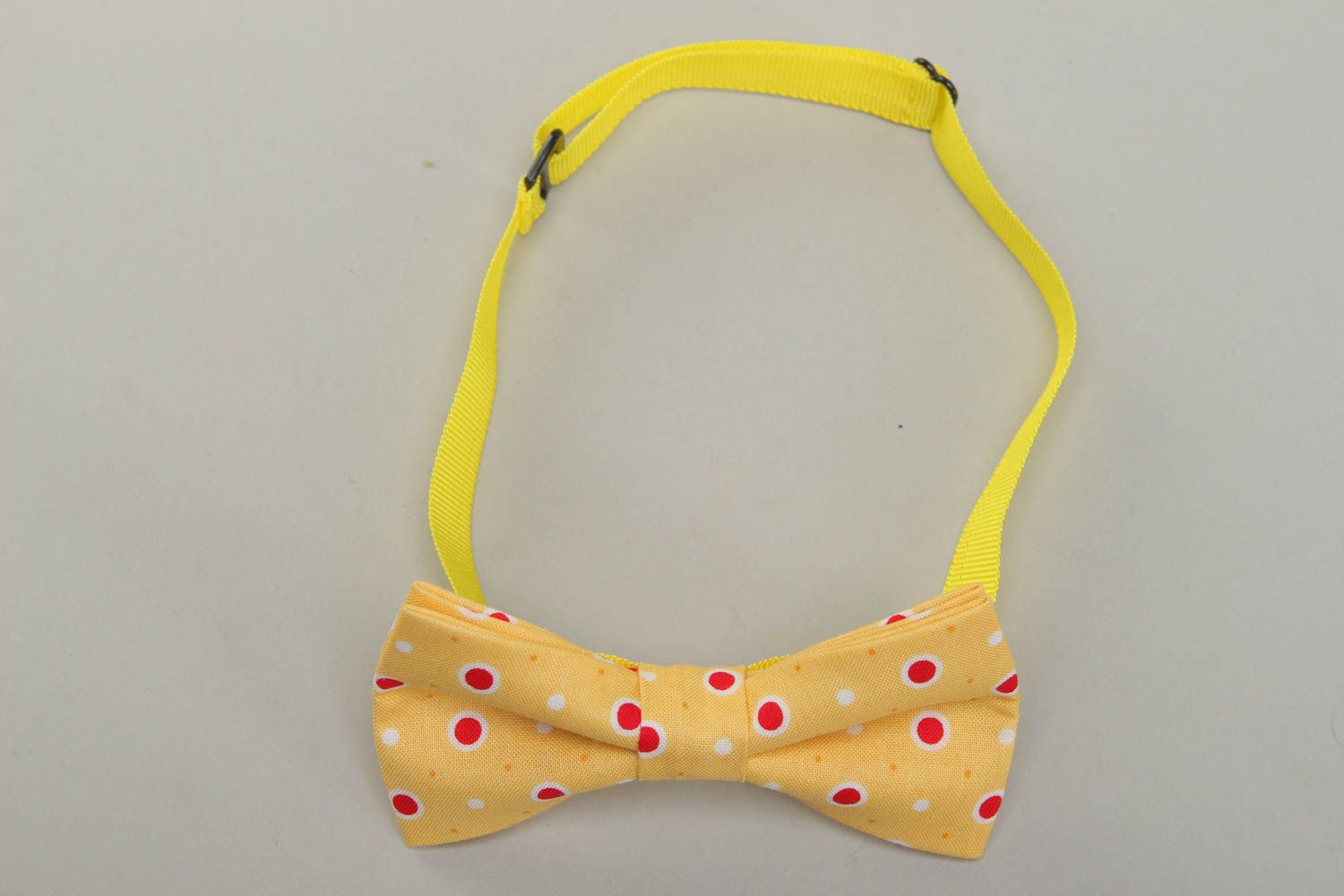 Bow tie made of yellow polka dot fabric photo 1
