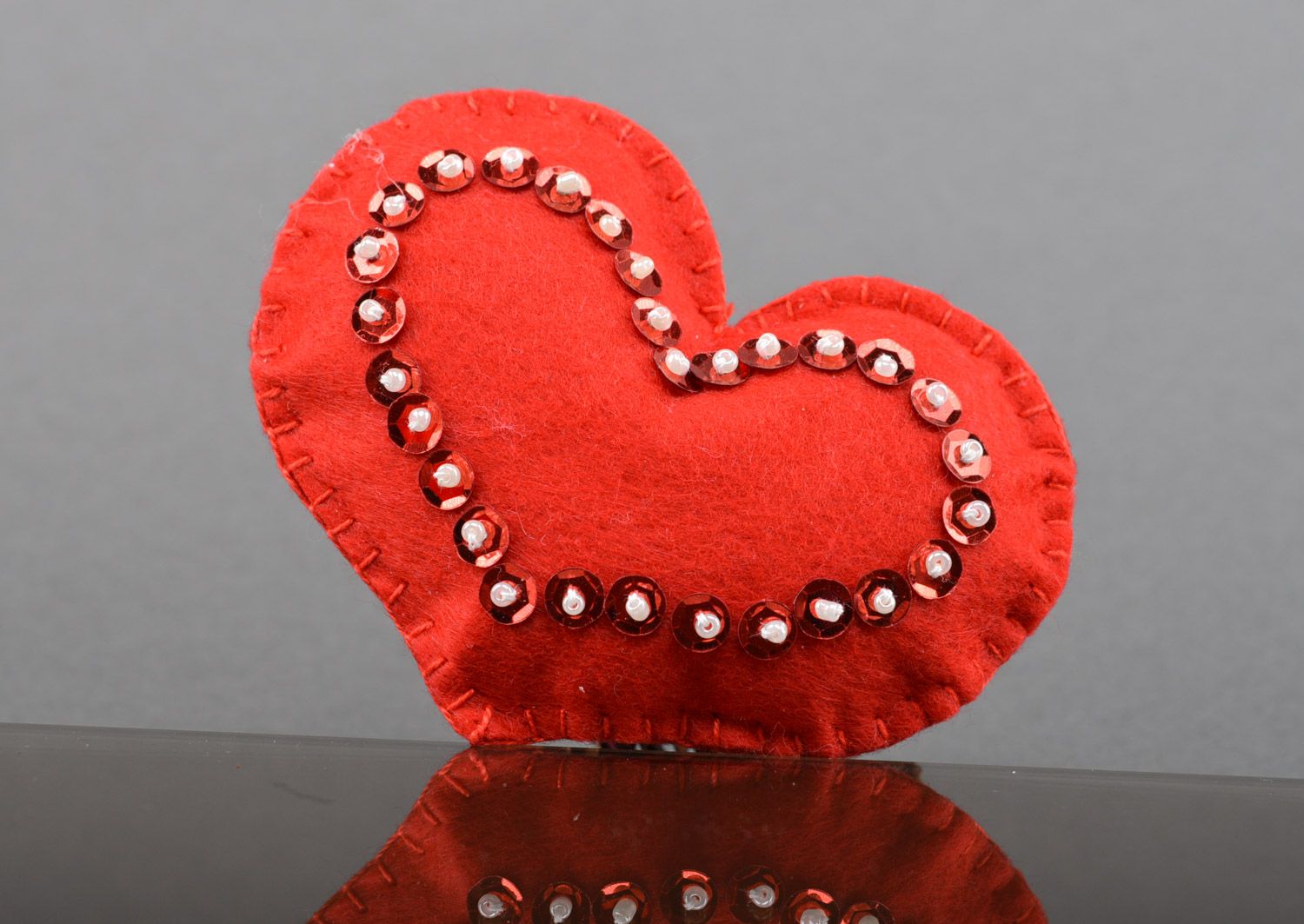 Handmade soft toy heart sewn of red felt decorated with spangles for interior photo 1