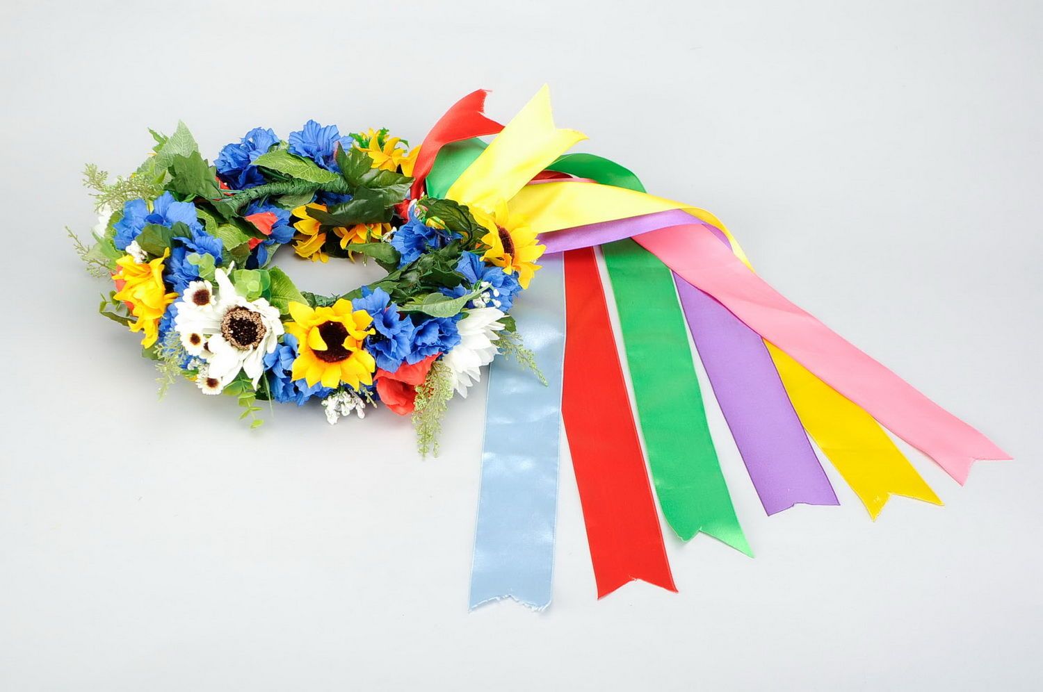 Wreath with artificial flowers and ribbons photo 1