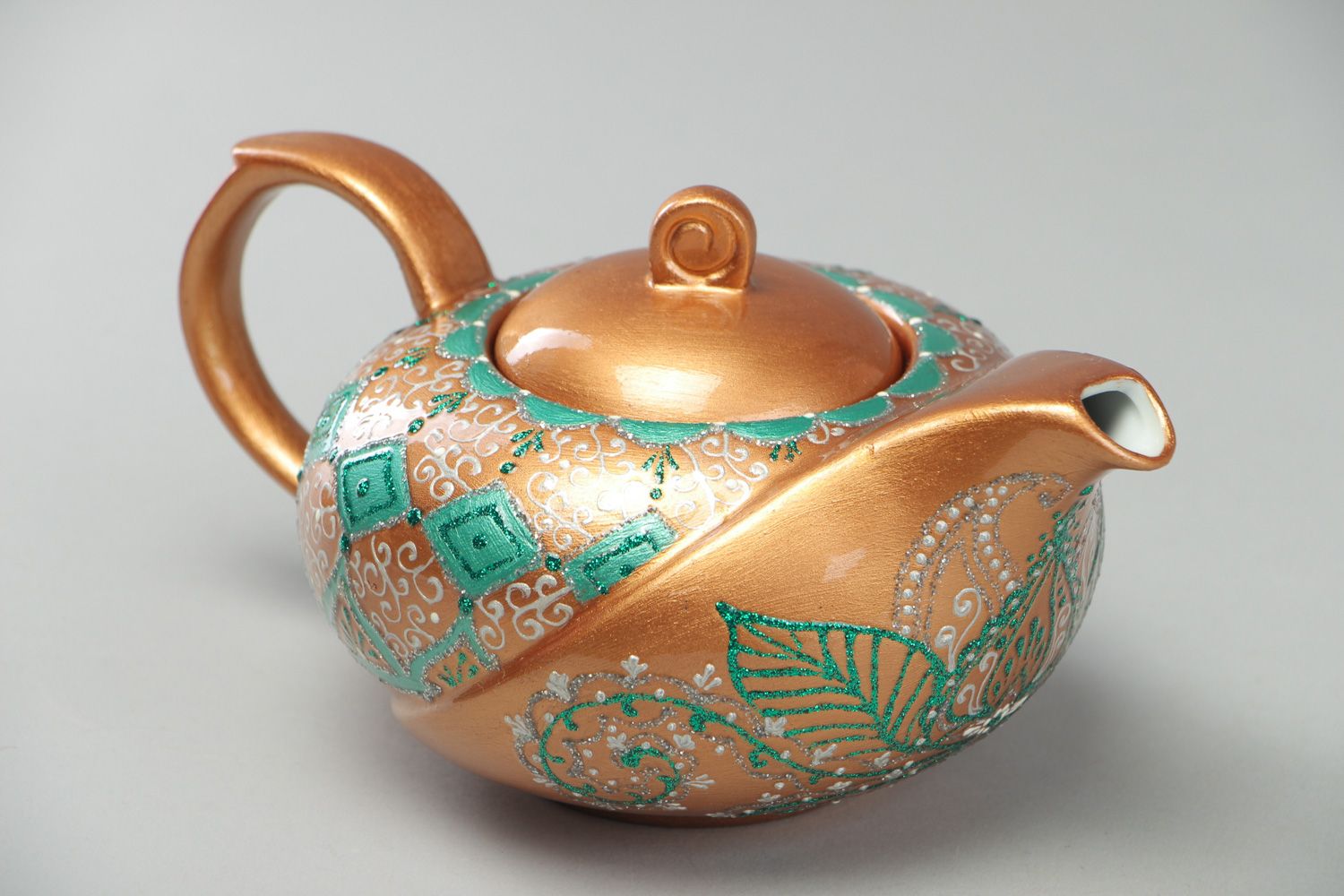 Handmade decorative ceramic teapot painted with ornaments on golden background photo 1