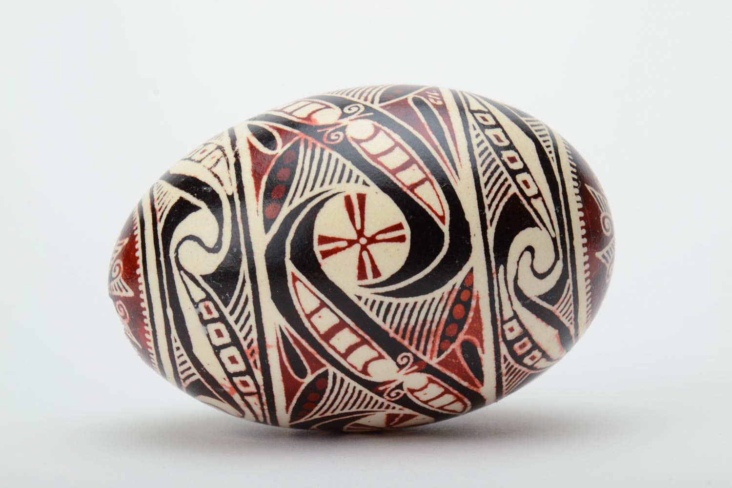 Handmade painted goose egg of black white and red colors ornamented using waxing technique photo 3