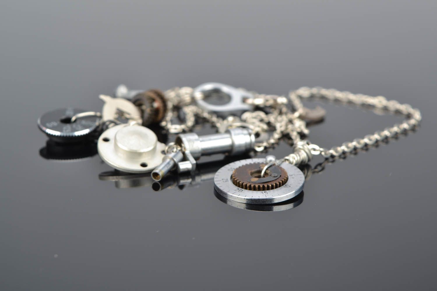Conjunto de jóias com mecanismos pulseira e pingente numa corrente foto 1