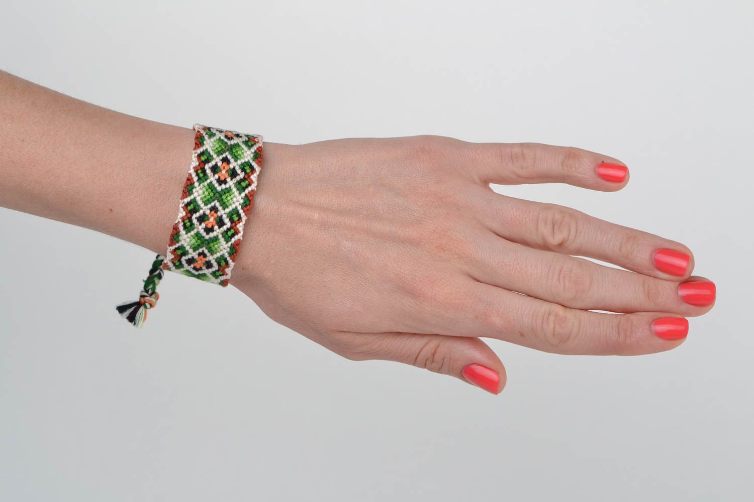 Handmade designer friendship bracelet with green and white geometric ornament  photo 2