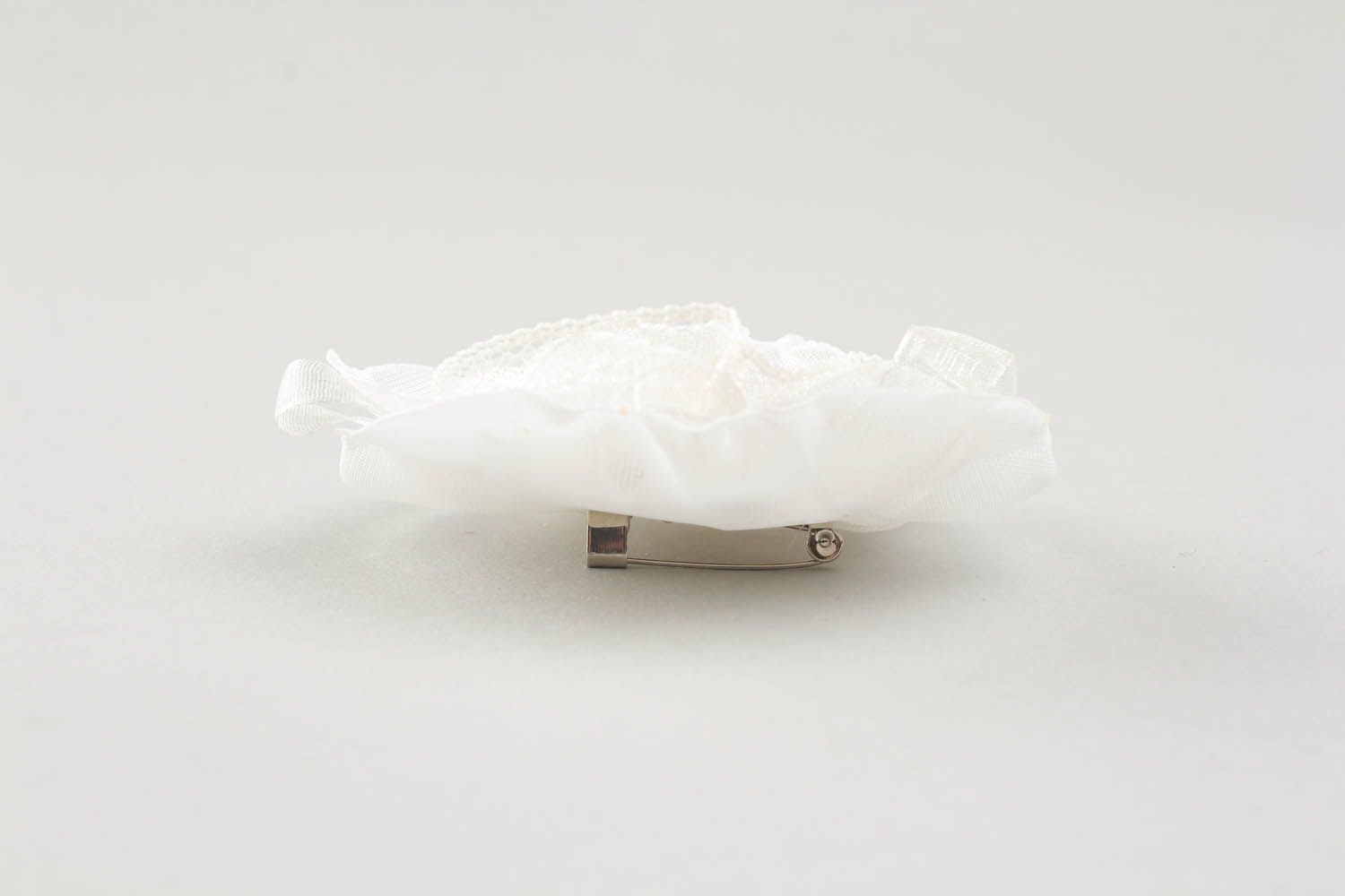 Broche artesanal feito de tecido leve branco equipado com acessórios de metal foto 3