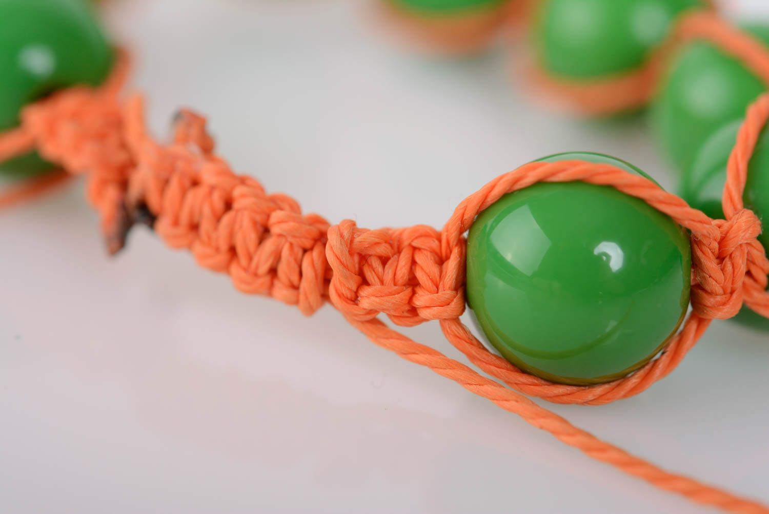 Künstlerisches Armband aus Perlen Plastik an Wachsschnur grün oranges handgemacht foto 4