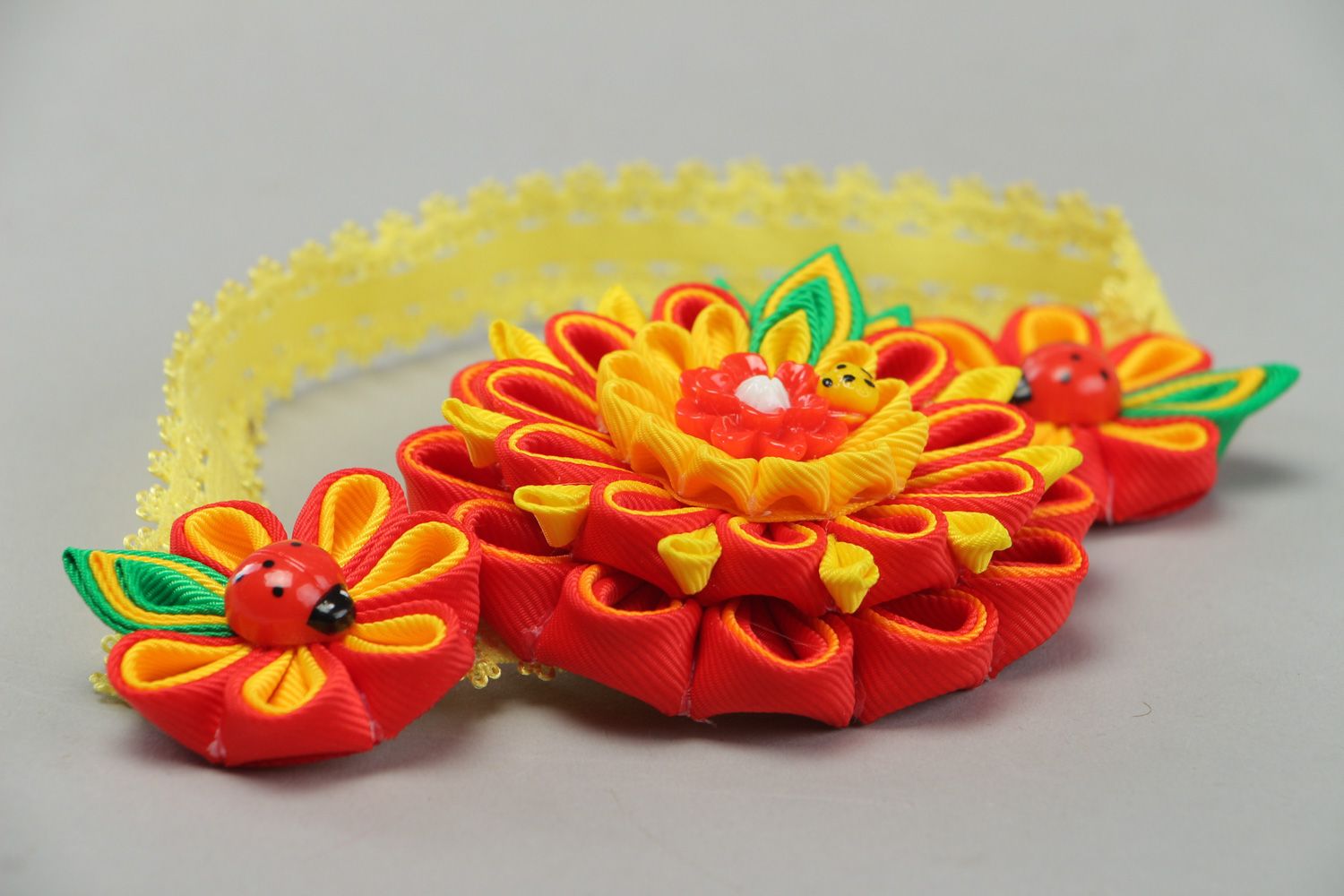 Handgemachtes Haarband mit Blume aus Bändern in Kanzashi Technik in Rot Gelb und Grün foto 2