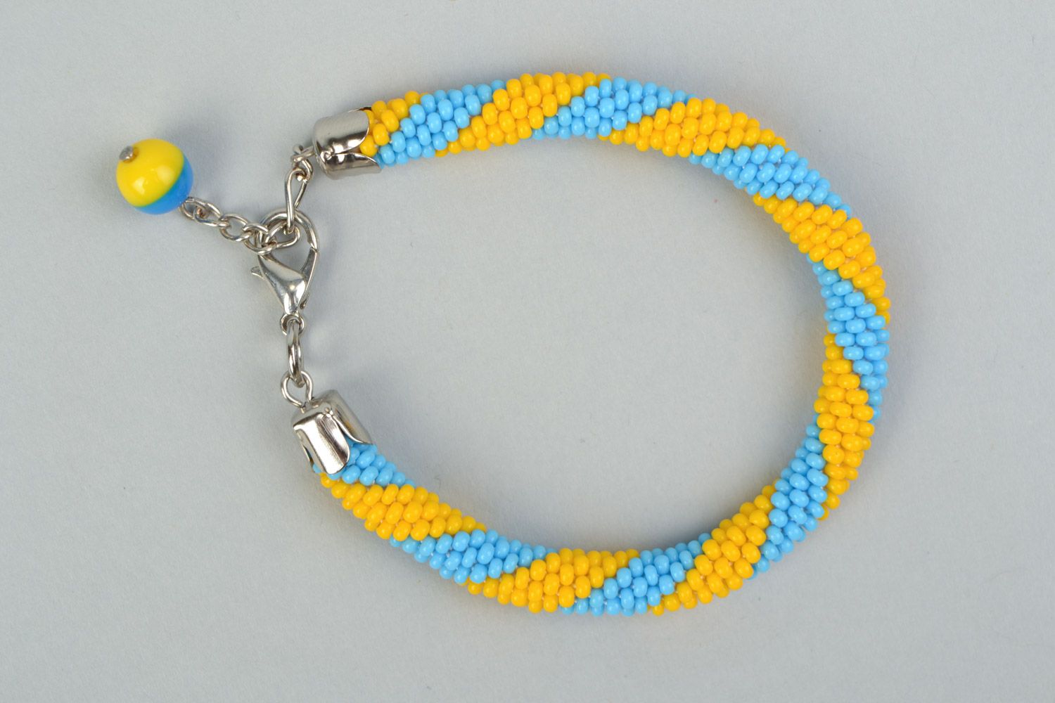 Bright handmade wrist bracelet woven of yellow and blue Czech beads  photo 2