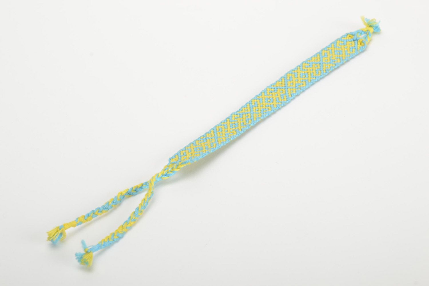 Handmade friendship wrist bracelet woven of blue and yellow threads with ties photo 2