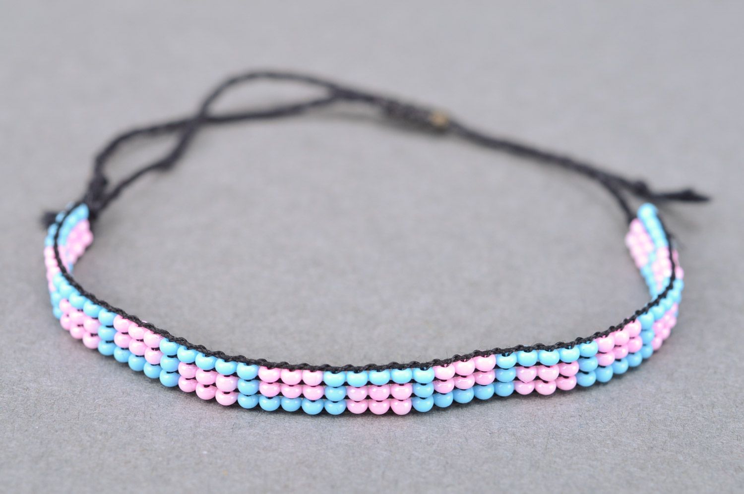 Thin handmade wrist bracelet woven of pink and blue beads with ties for women photo 2