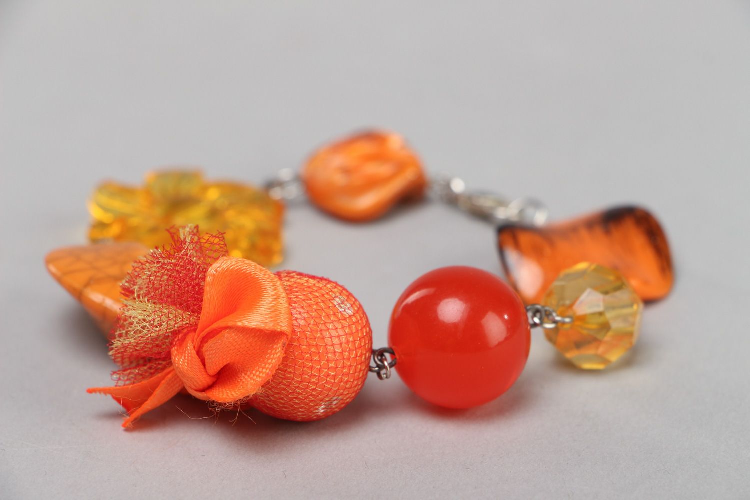 Bright handmade wrist bracelet with orange plastic beads of different shapes photo 2