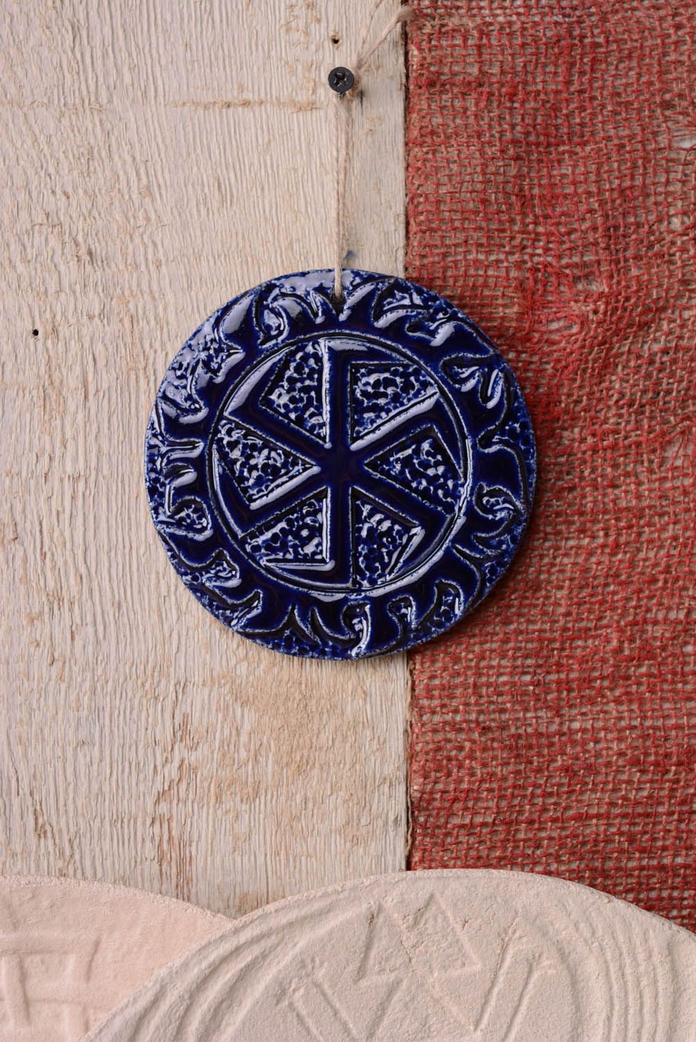 Prato talismã artesanal de argila coberto com esmalte com um símbolo antigo eslavo foto 3