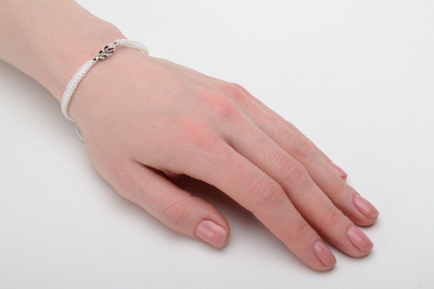 This handmade white friendship wrist bracelet woven using macrame technique photo 2