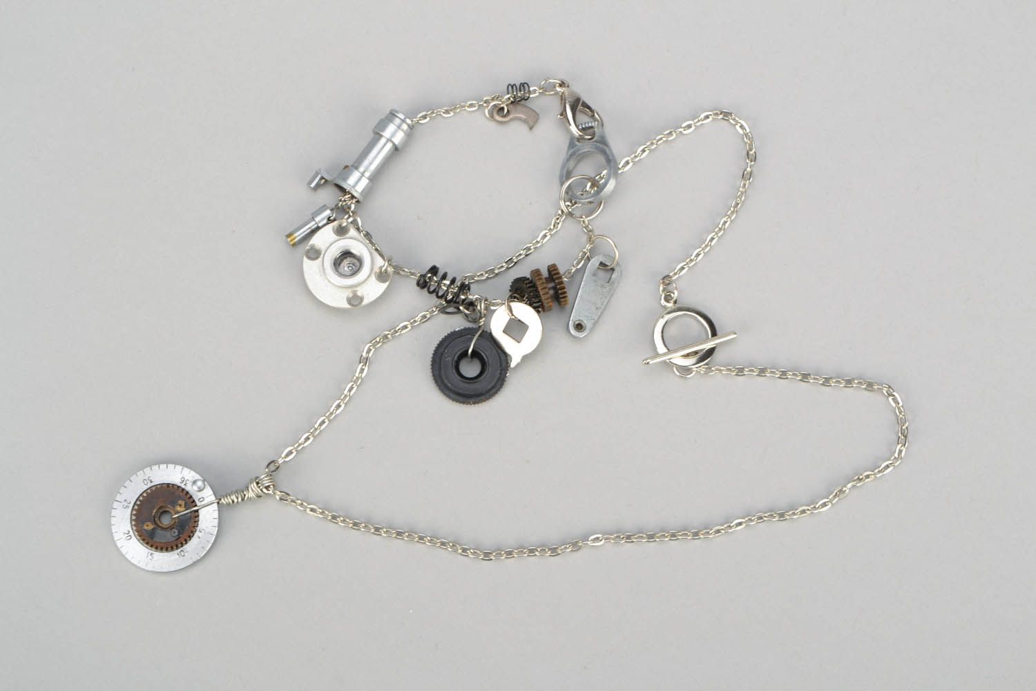 Conjunto de jóias com mecanismos pulseira e pingente numa corrente foto 3