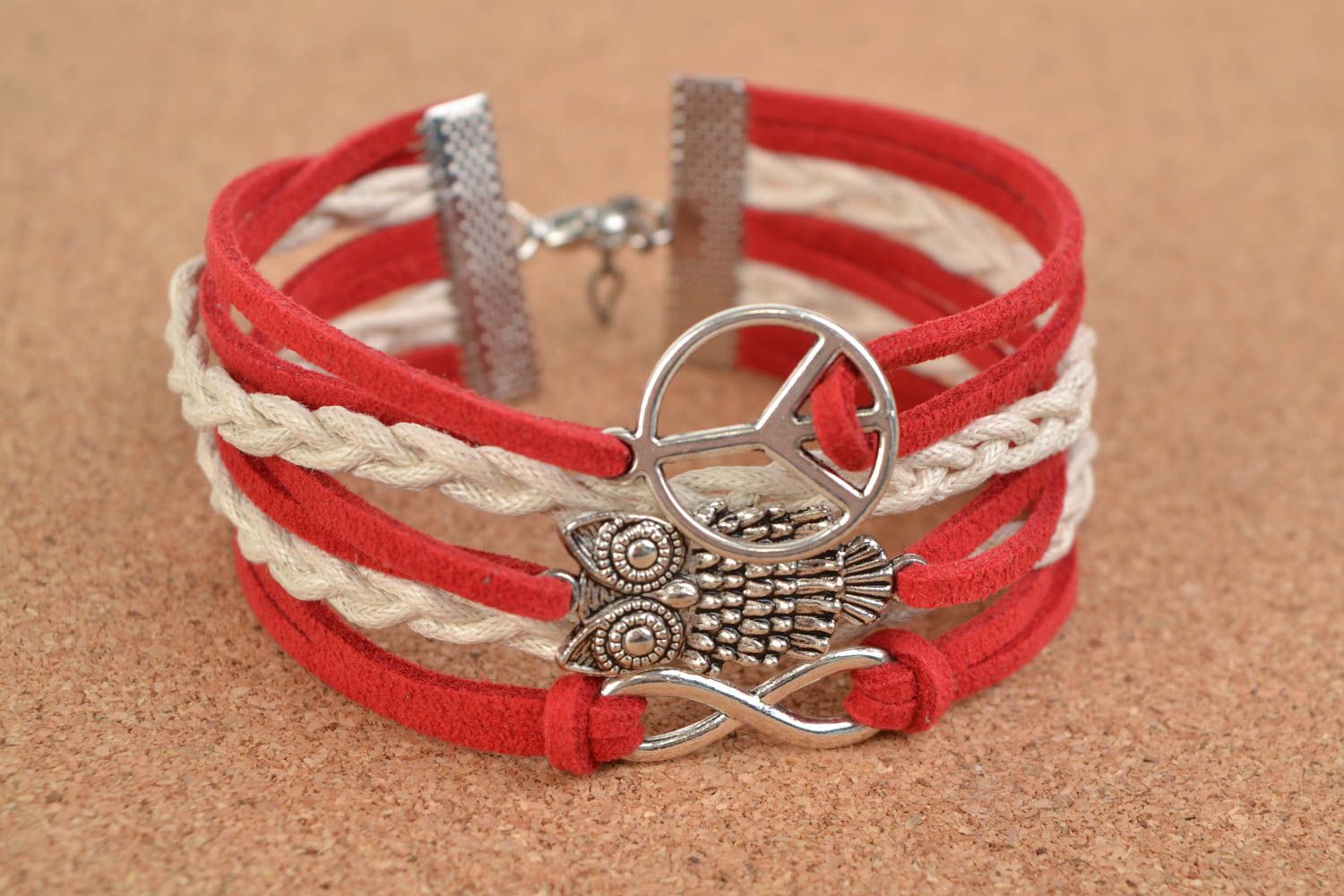 Red handmade woven suede cord bracelet with inserts in the shape of various signs photo 1