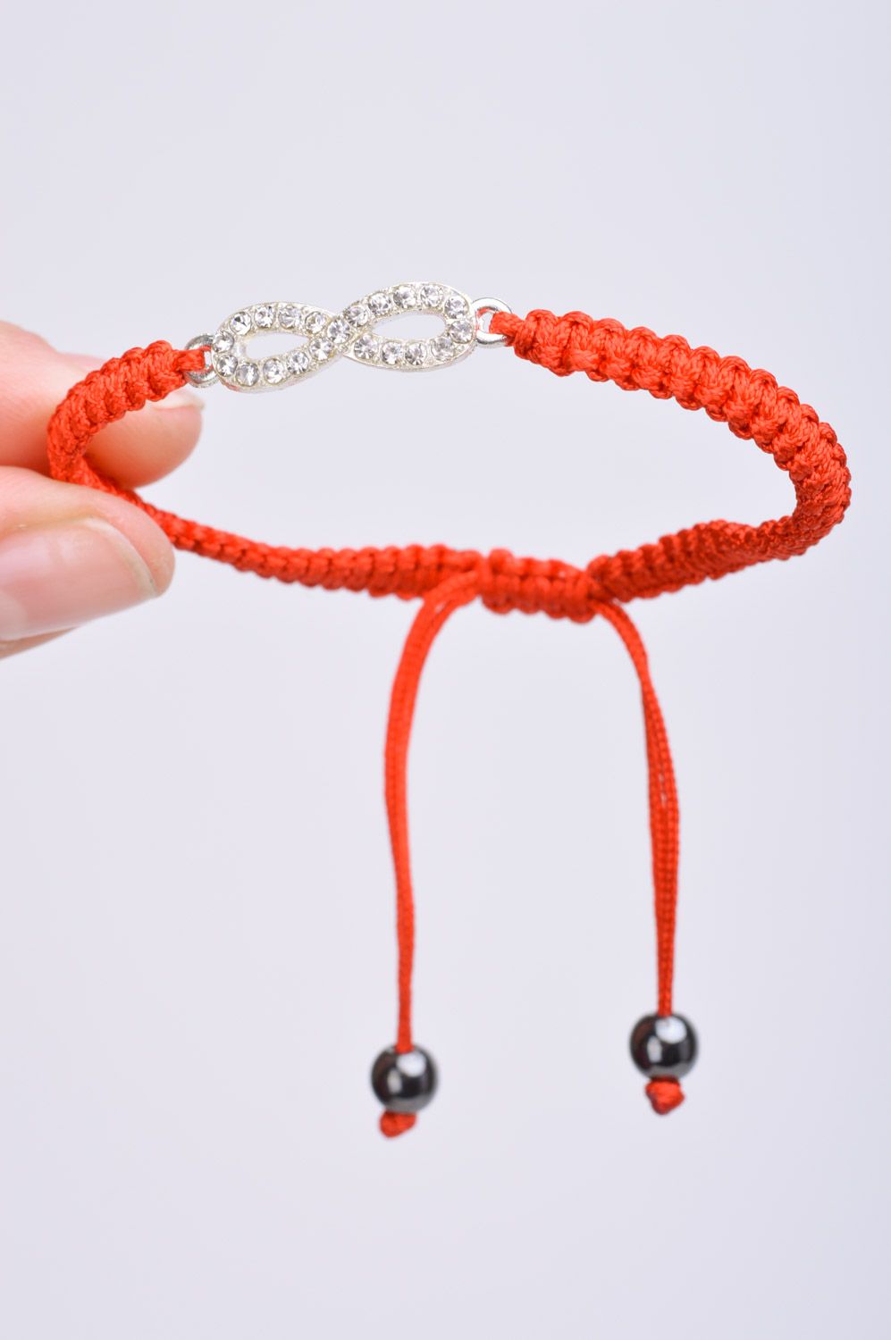 Handmade thin friendship wrist bracelet woven of red threads with infinity sign photo 3