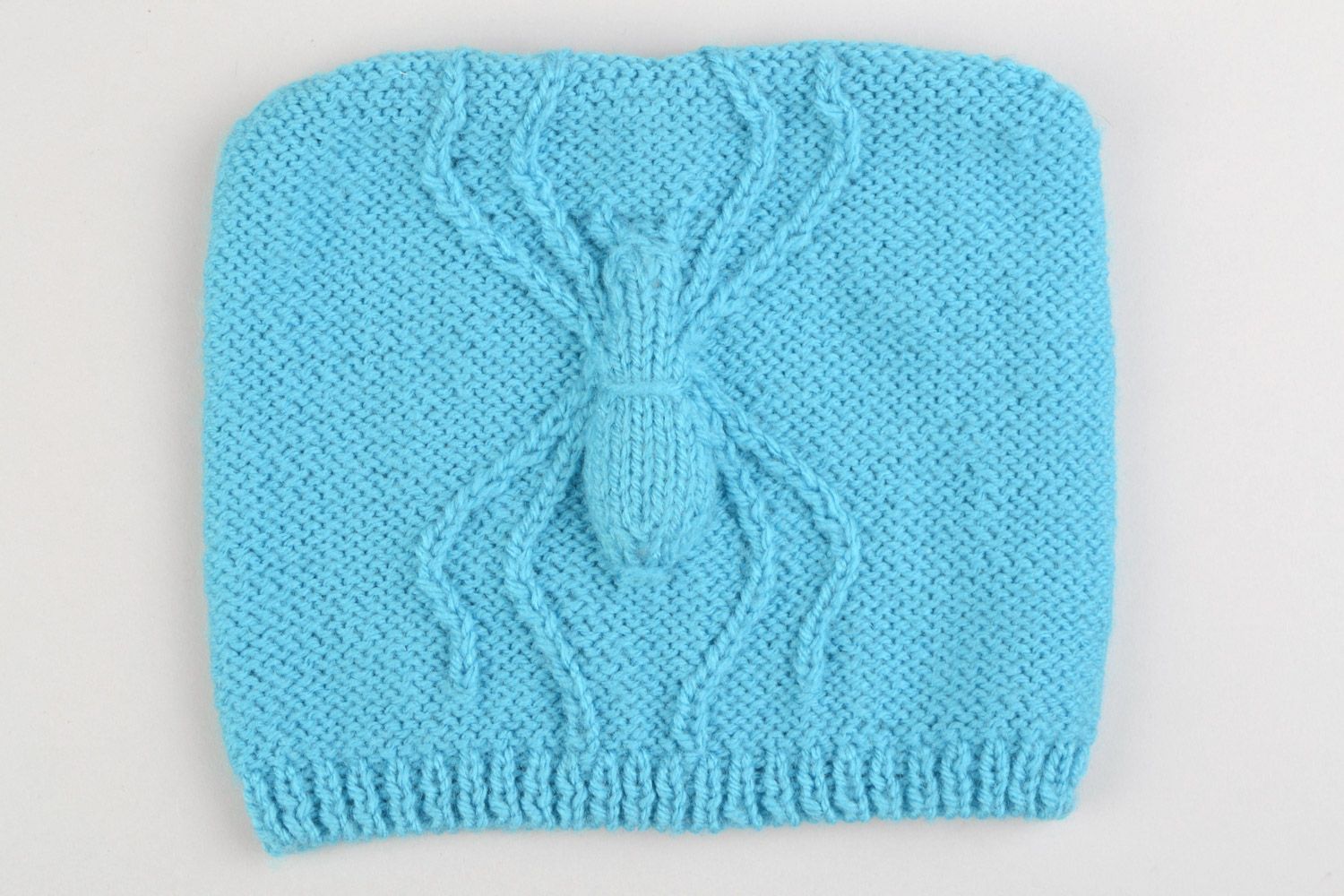 Knitted warm hat made of acrylic threads with a three-dimensional pattern in the form of a blue spider photo 3