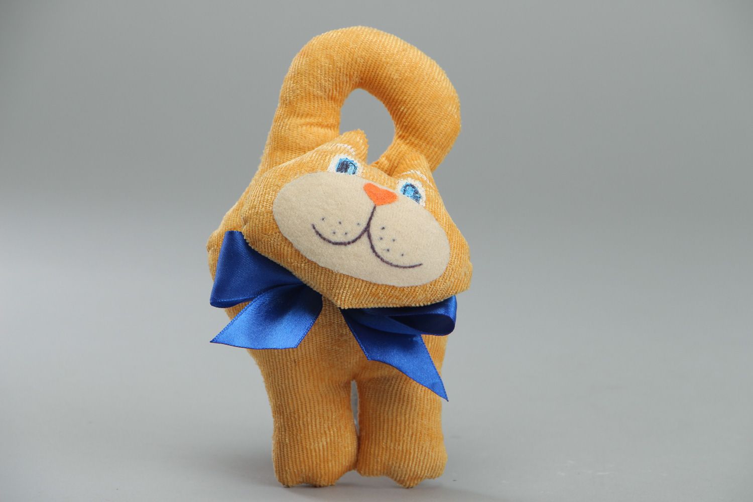 Cute handmade soft toy in the shape of yellow cat with blue bow for children photo 1