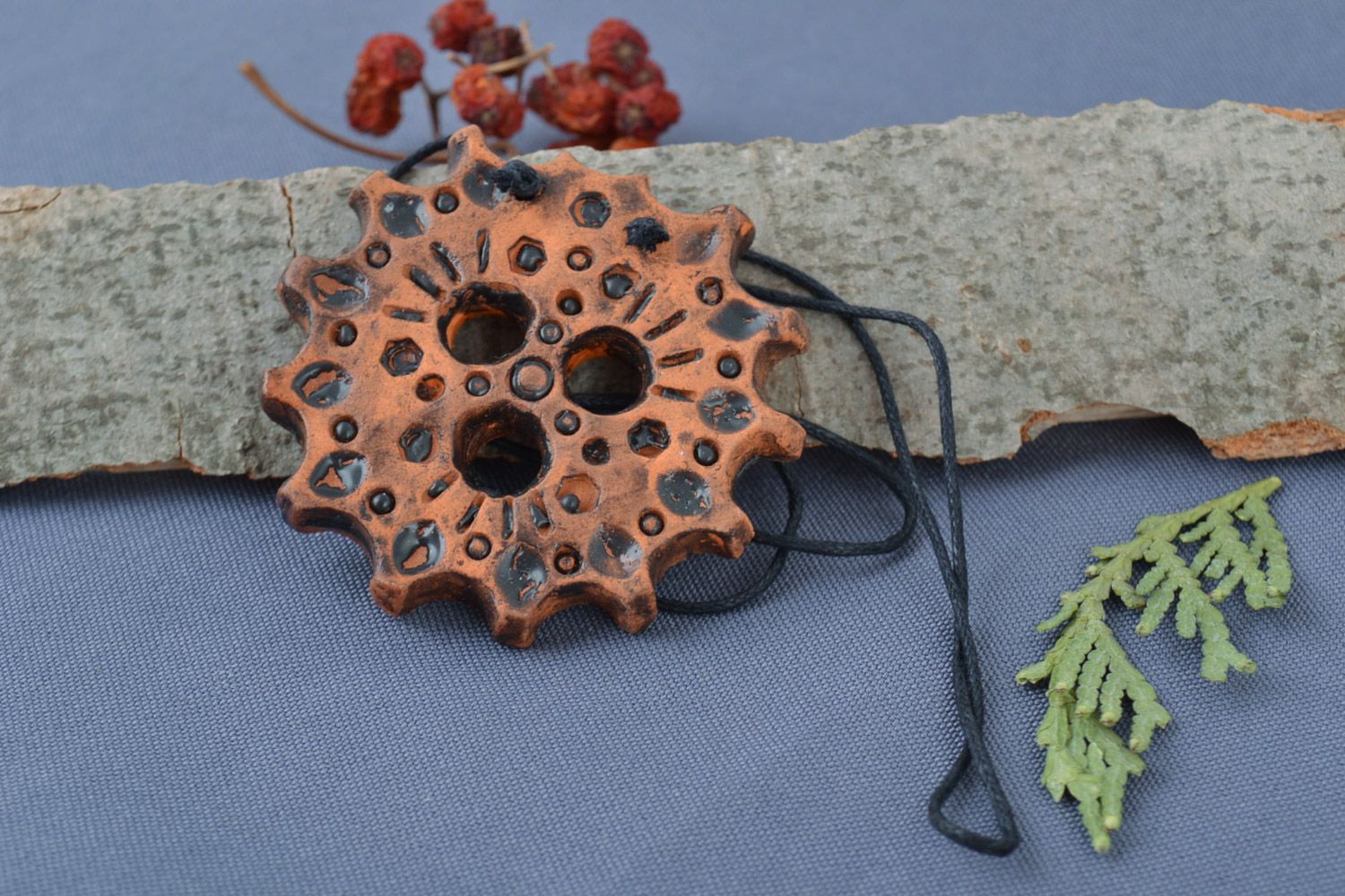 Handmade ceramic middle-sized round pendant in the shape of gear wheel on cord photo 1