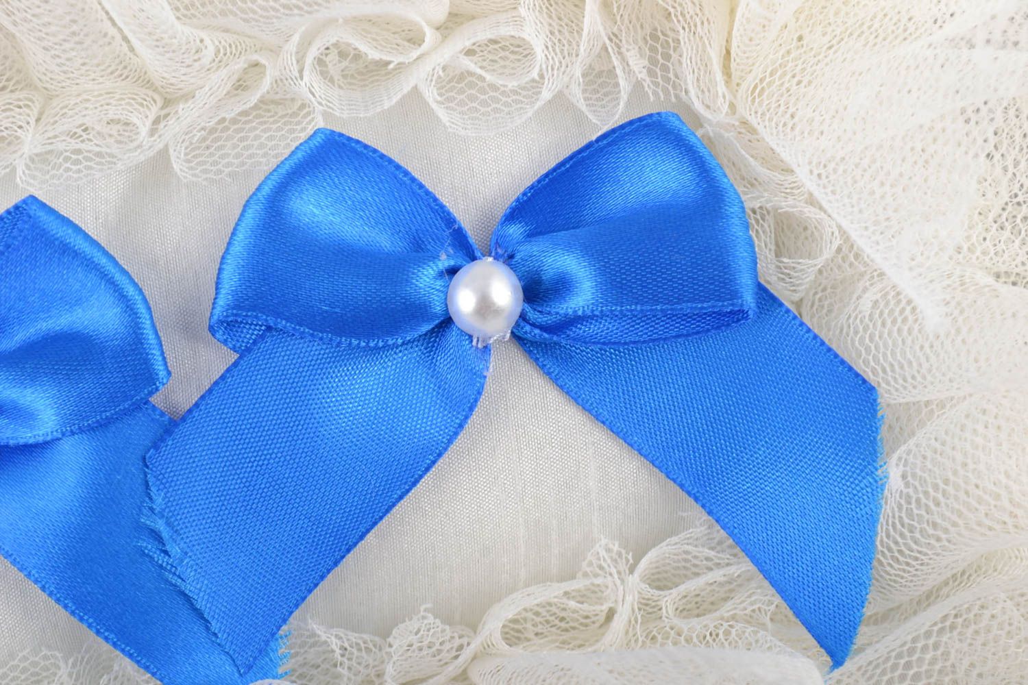 Weißes Ringkissen mit Spitze mit blauen Schleifen zartes stilvolles Accessoire foto 2