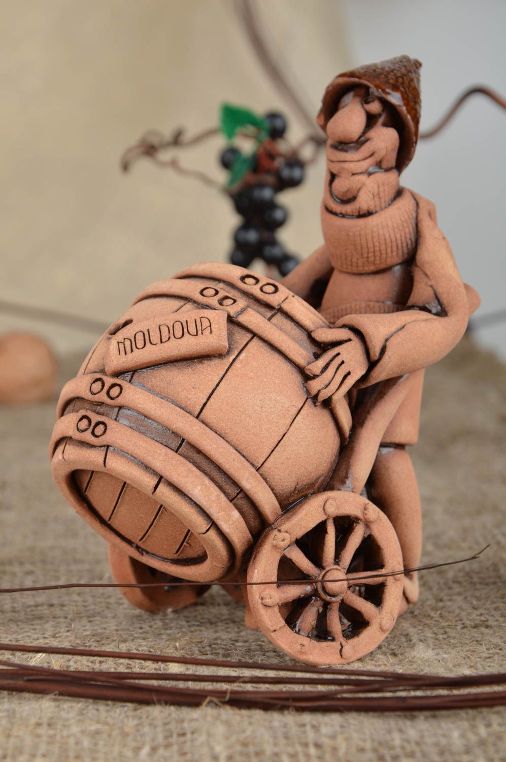 Figura de arcilla artesanal marrón con forma de hombre con barril vinicultor foto 1