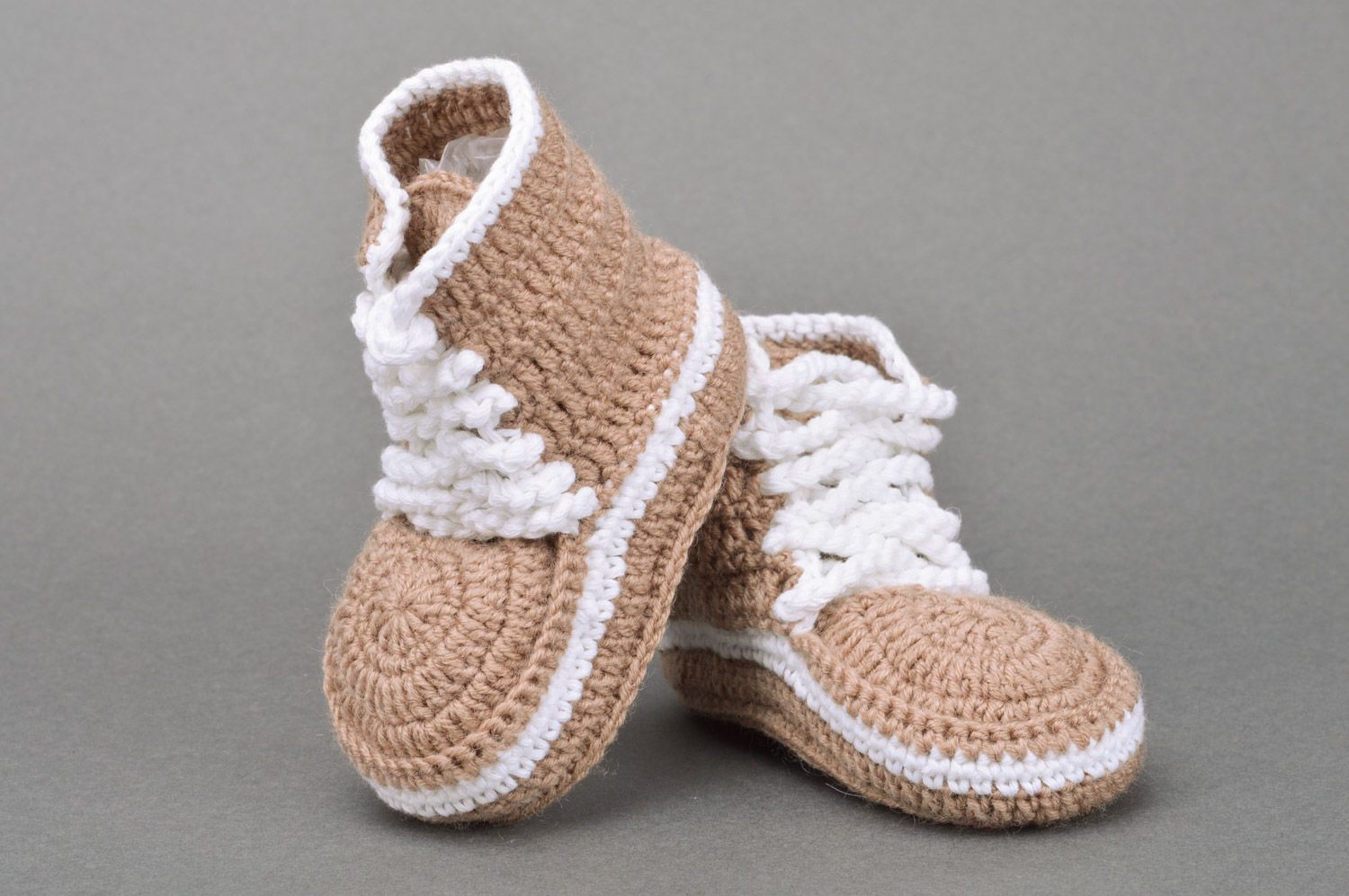 Originelle hellbraune gehäkelte Babyschuhe mit Schuhbändern in Form der Turnschuhen foto 2