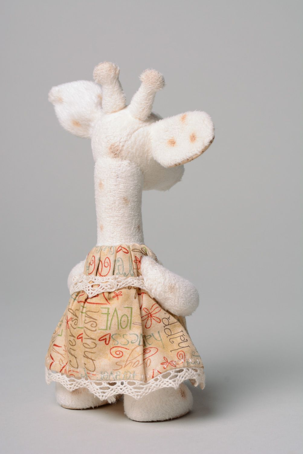 Juguete hecho a mano de peluche para niños con forma de jirafa blanca en vestido foto 4