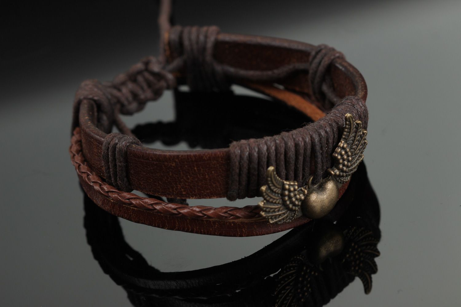 Dark brown handmade wrist bracelet woven of genuine leather with metal wings photo 1