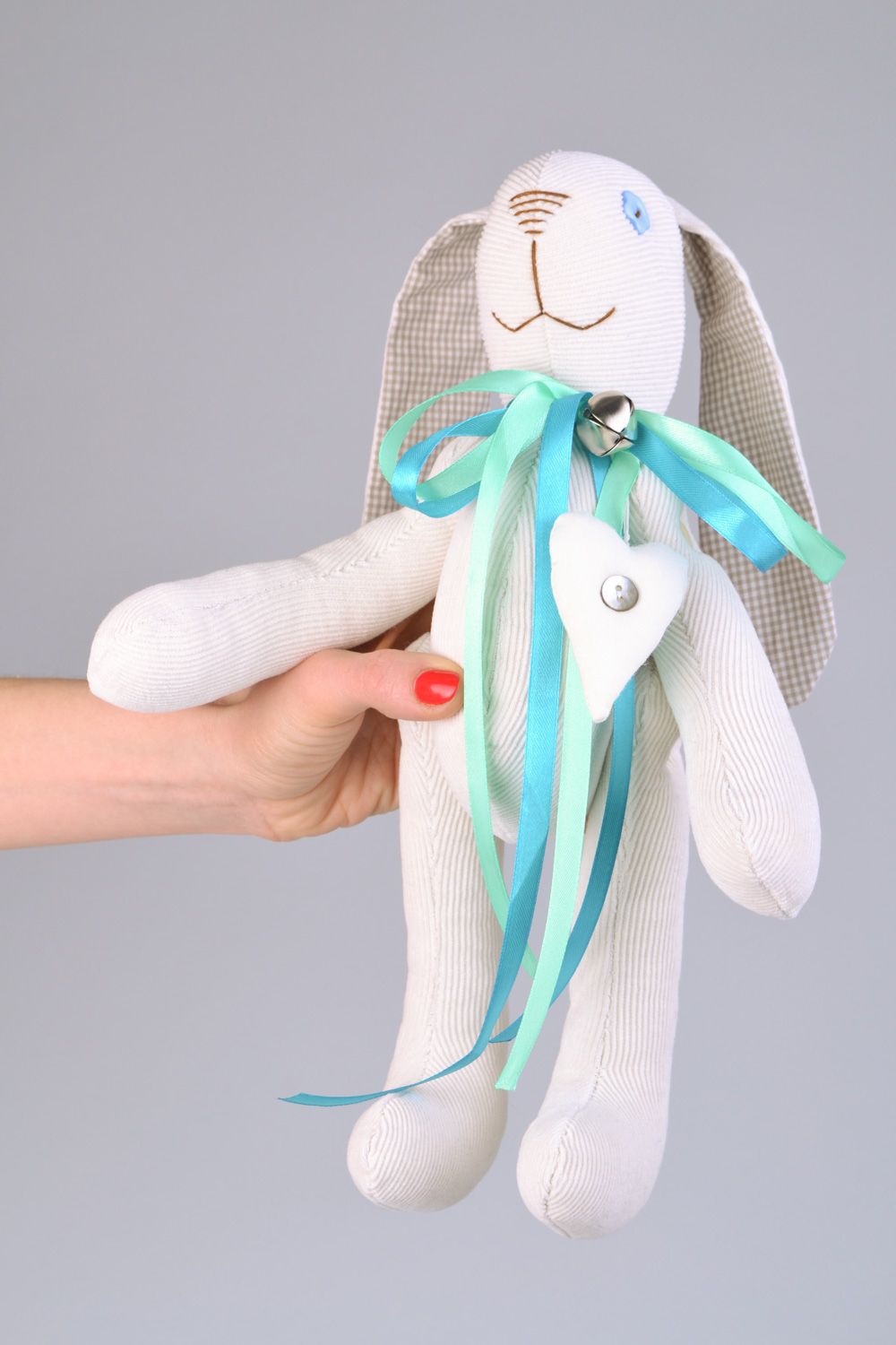 Handmade designer soft toy rabbit sewn of fabric of white color with blue bow photo 2
