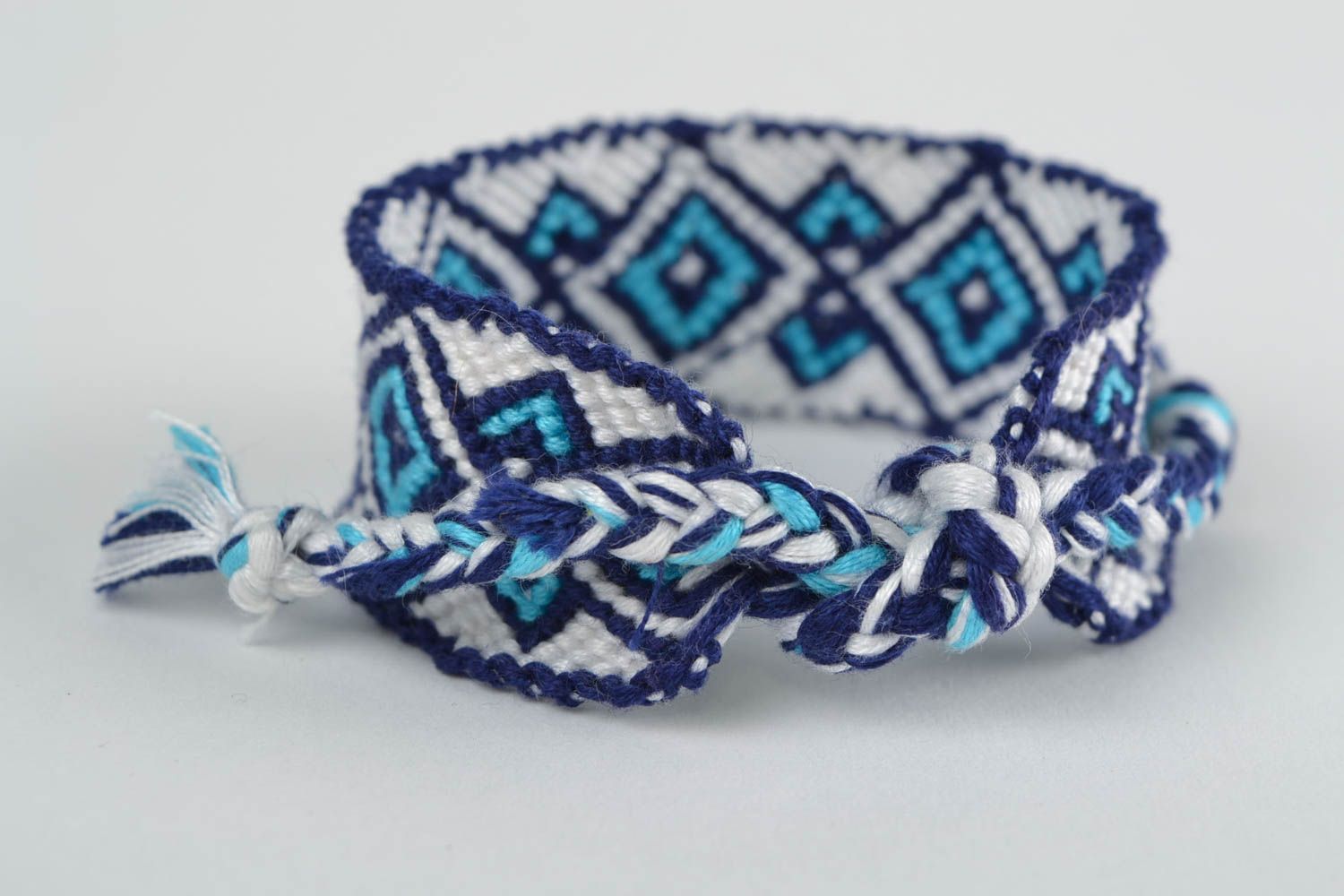 Handmade macrame bracelet woven of white and blue embroidery floss with ornament photo 4