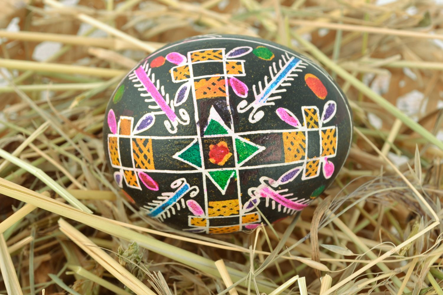 Homemade painted chicken Easter egg with cross pattern on black background  photo 1