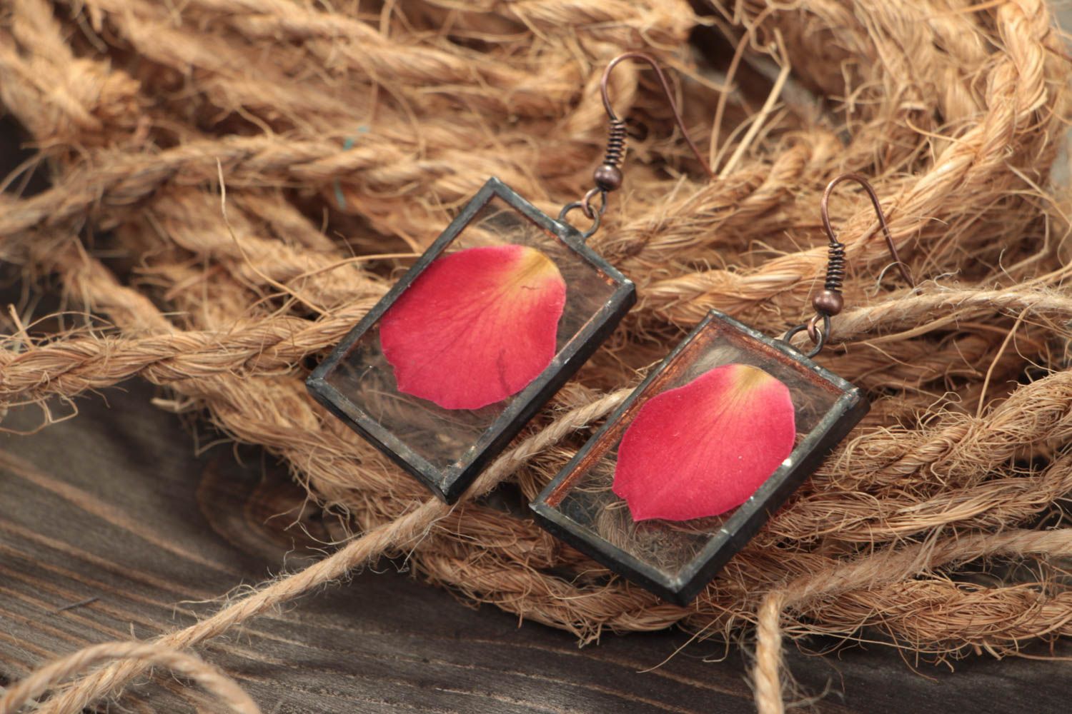 Pendientes artesanales rectangulares con pétalos rojos bajo el cristal foto 1