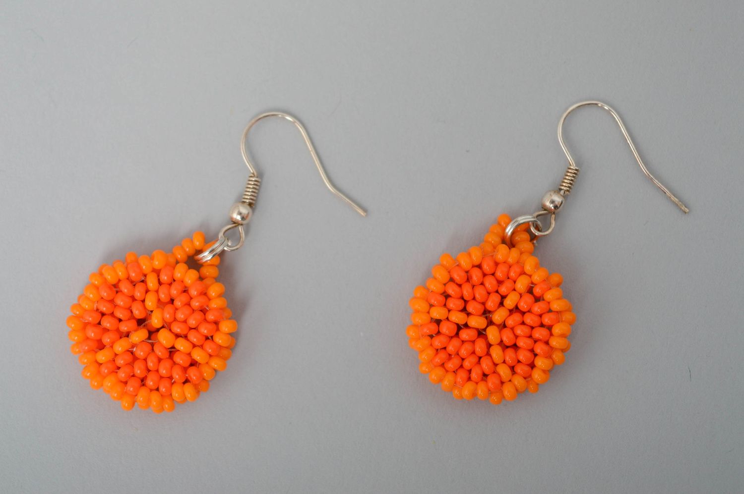Round beaded earrings of orange color photo 1