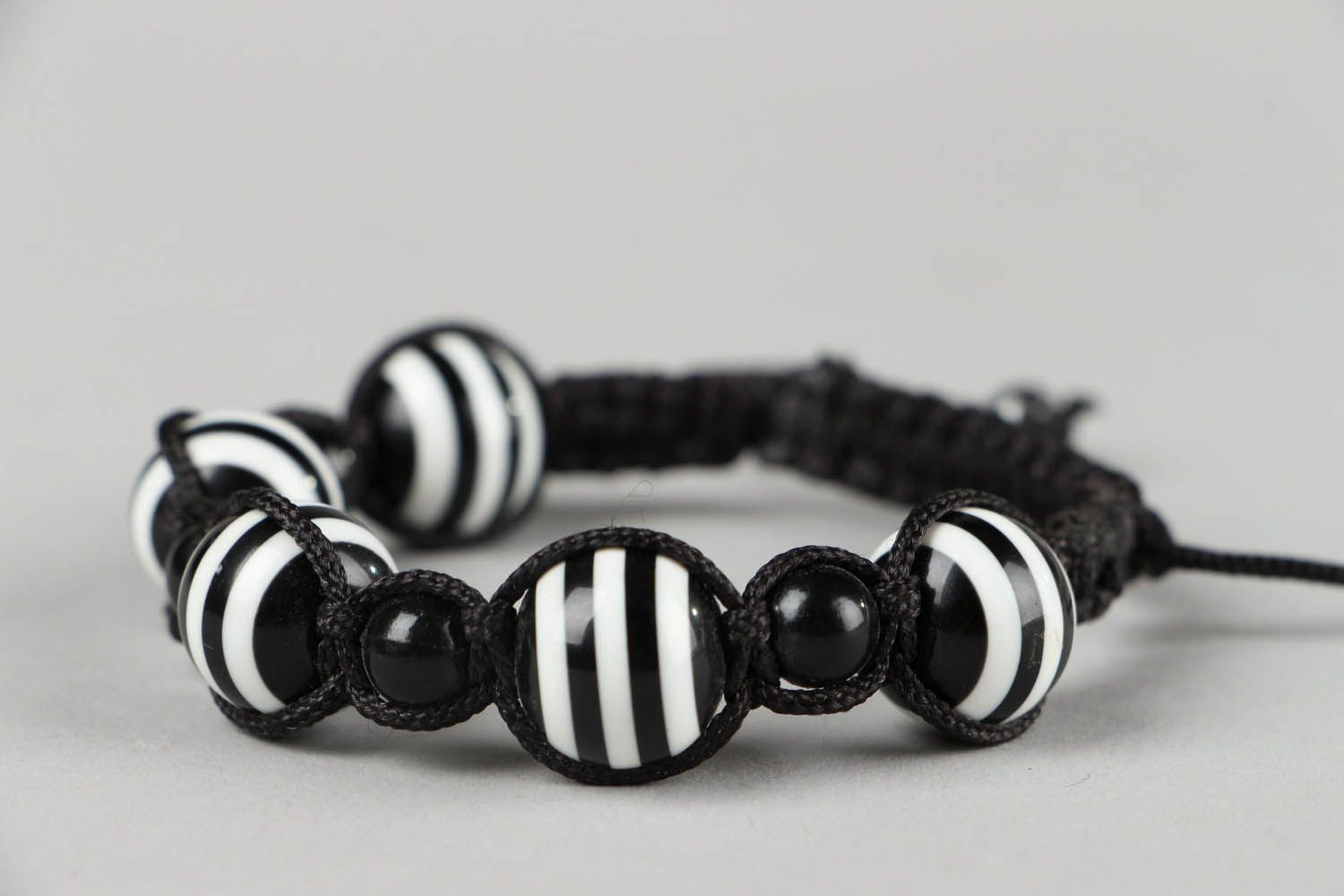 Черно-белый плетеный браслет с бусинами фото 1