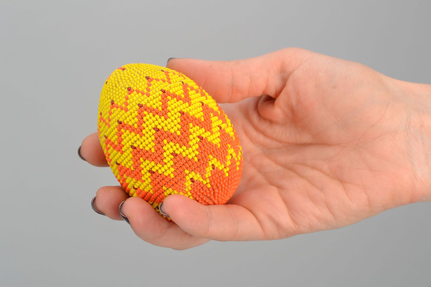 Wooden egg woven over with orange beads photo 2