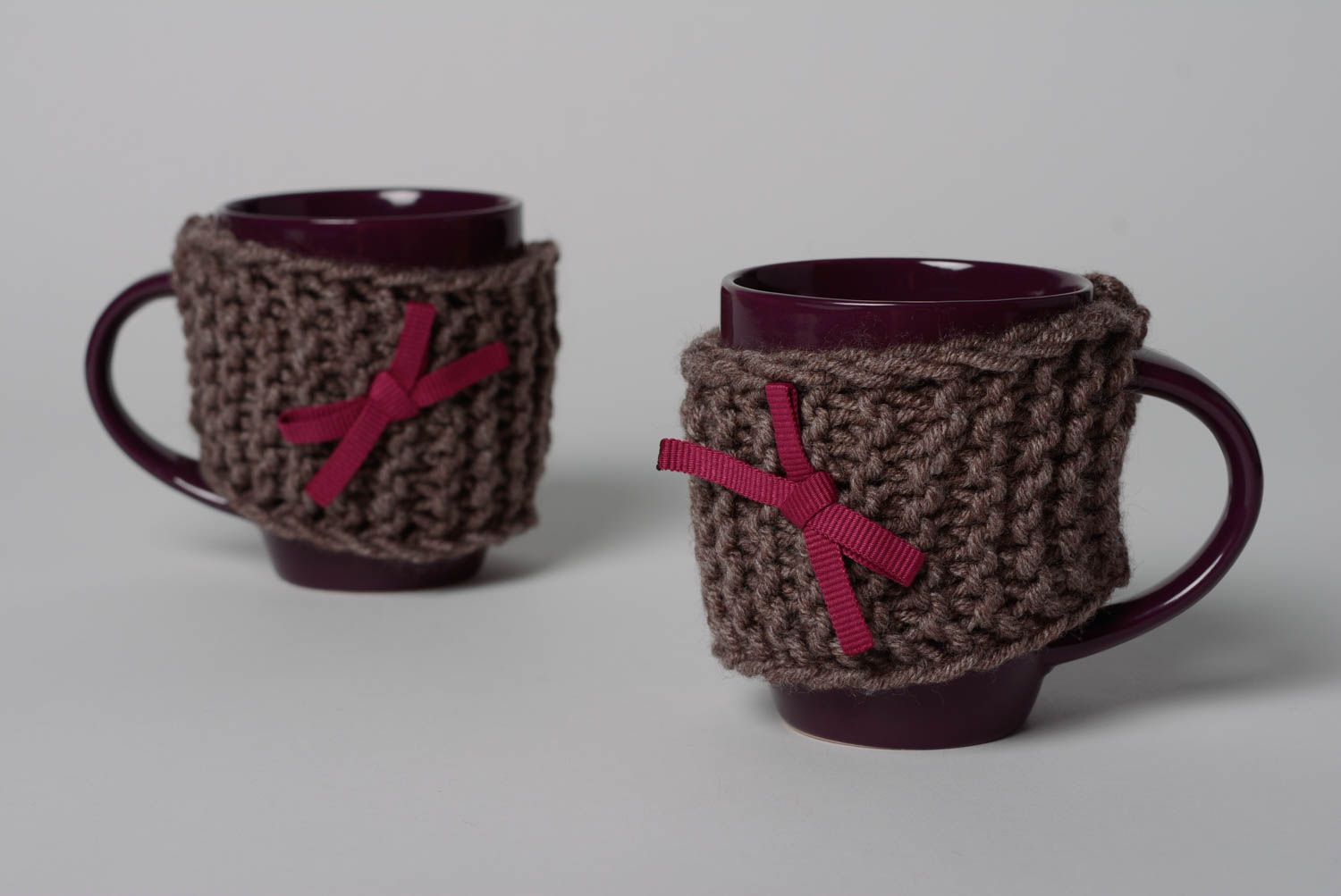Set of two porcelain cups with  knitted cozies with bows photo 1