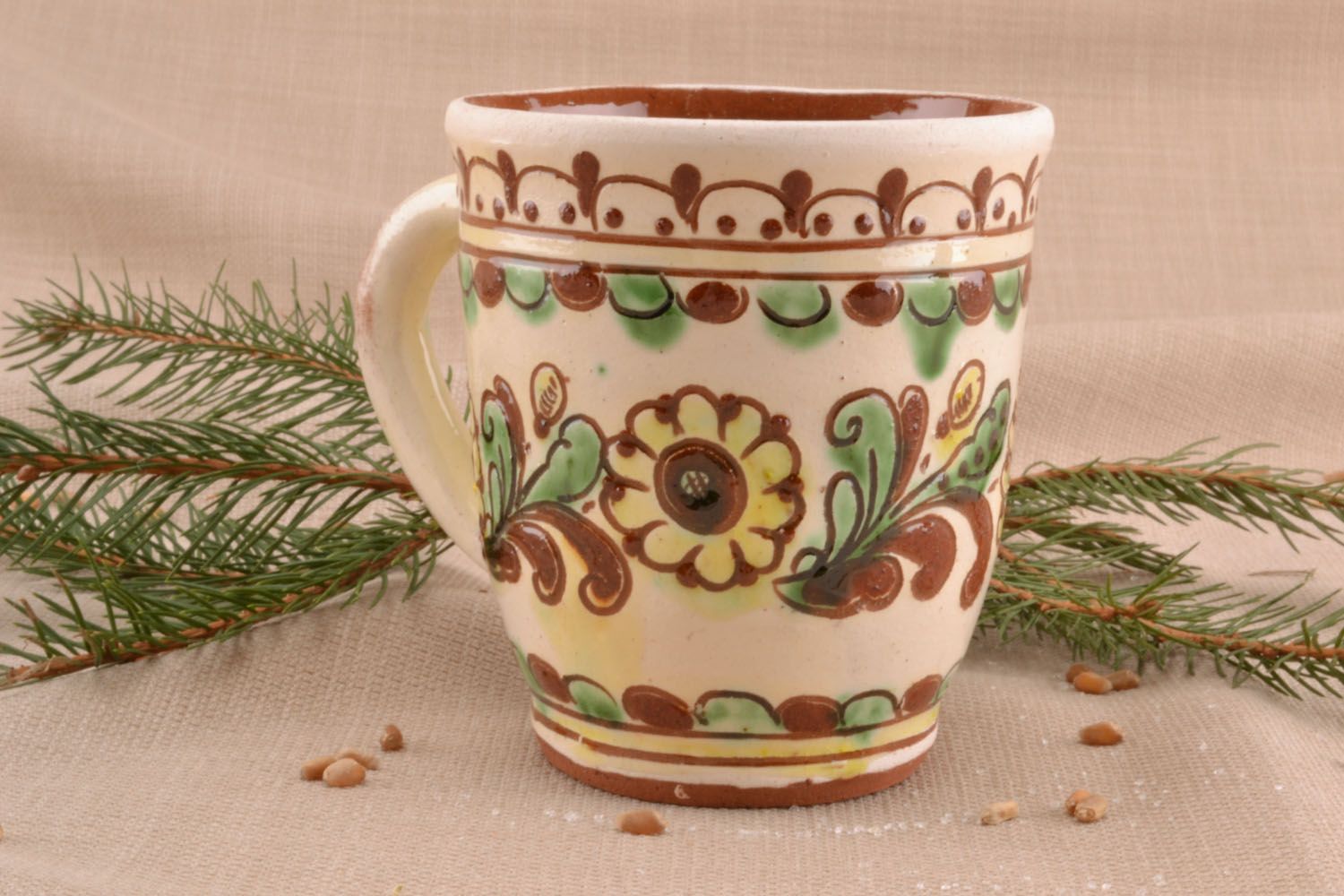 Decorative clay glazed cup in beige, cherry, and green colors with handle photo 1