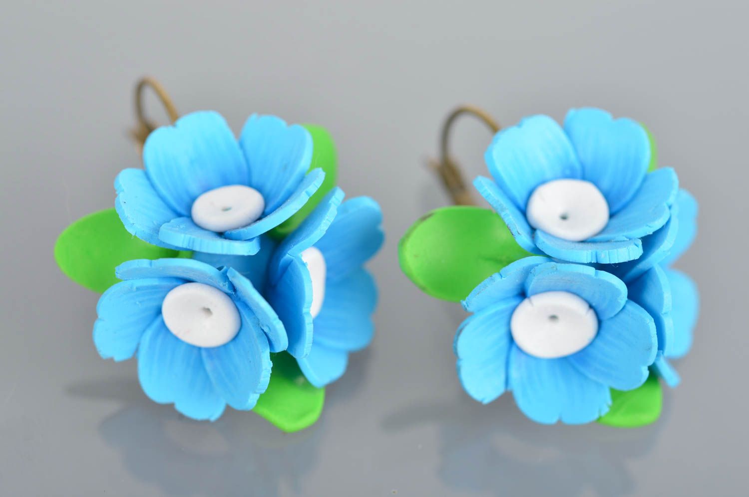 Kleine schöne grün hellblaue handgemachte Ohrringe aus Polymerton mit Blumen foto 2