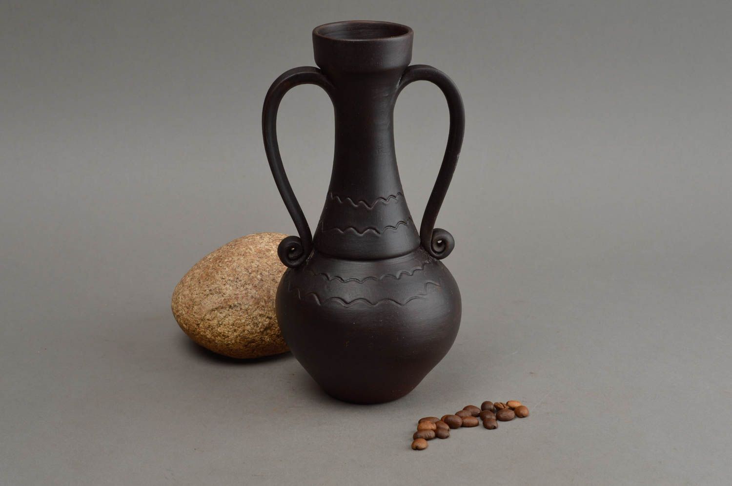Schwarze handgemachte Vase aus Ton mit Musterung und zwei gedrehten Griffen foto 1