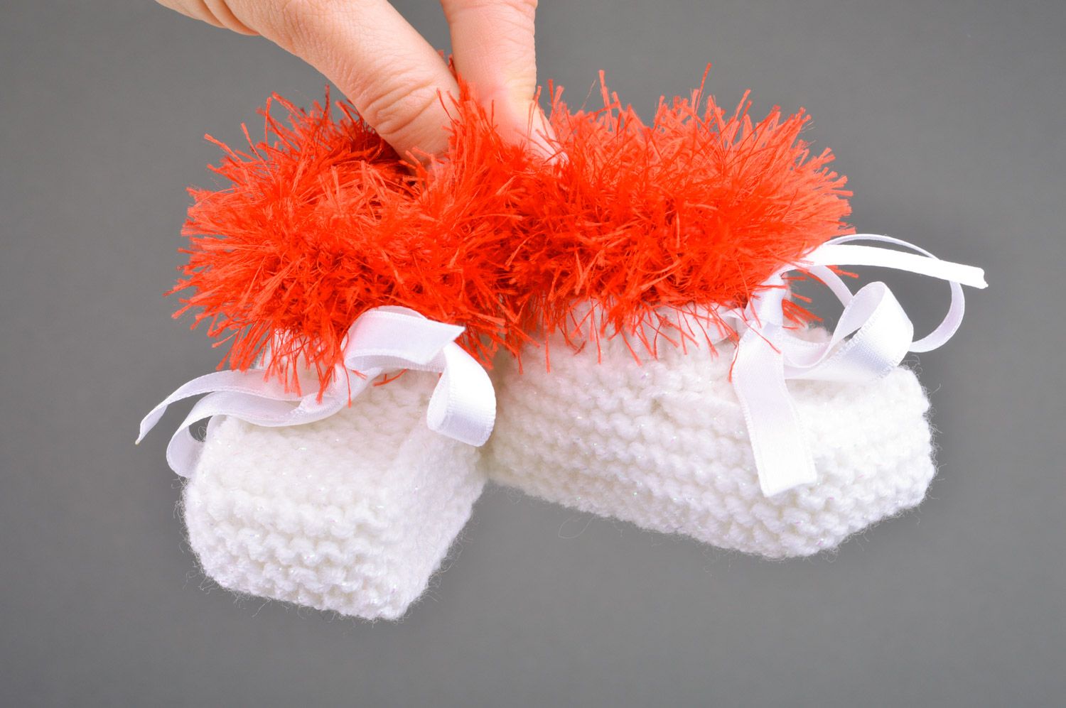 Beautiful handmade knitted baby booties of white color with red edge and satin bow photo 3