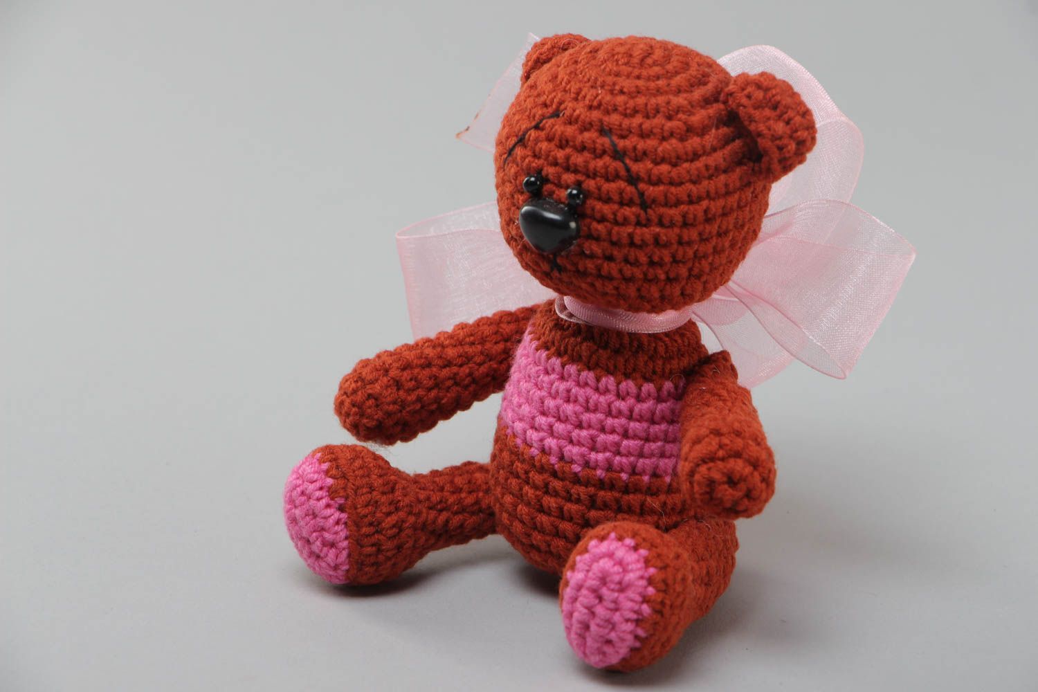 Handmade soft toy crocheted of acrylic threads brown bear with big pink bow photo 2