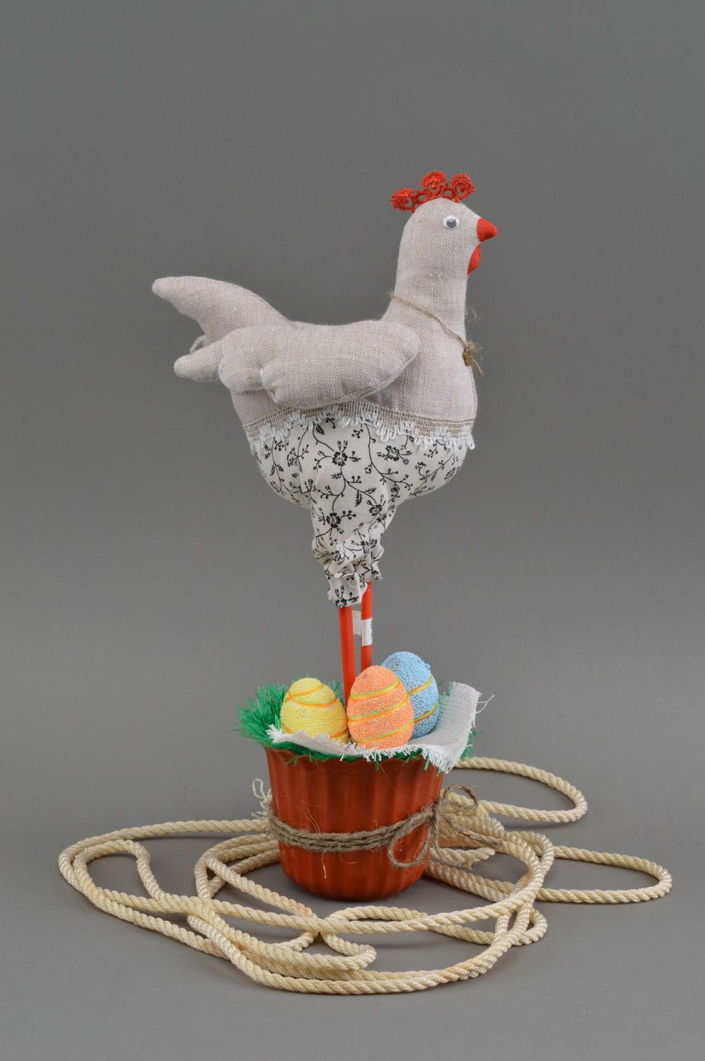 Interior beautiful cute toy hen on basket with orange yellow and blue eggs photo 2