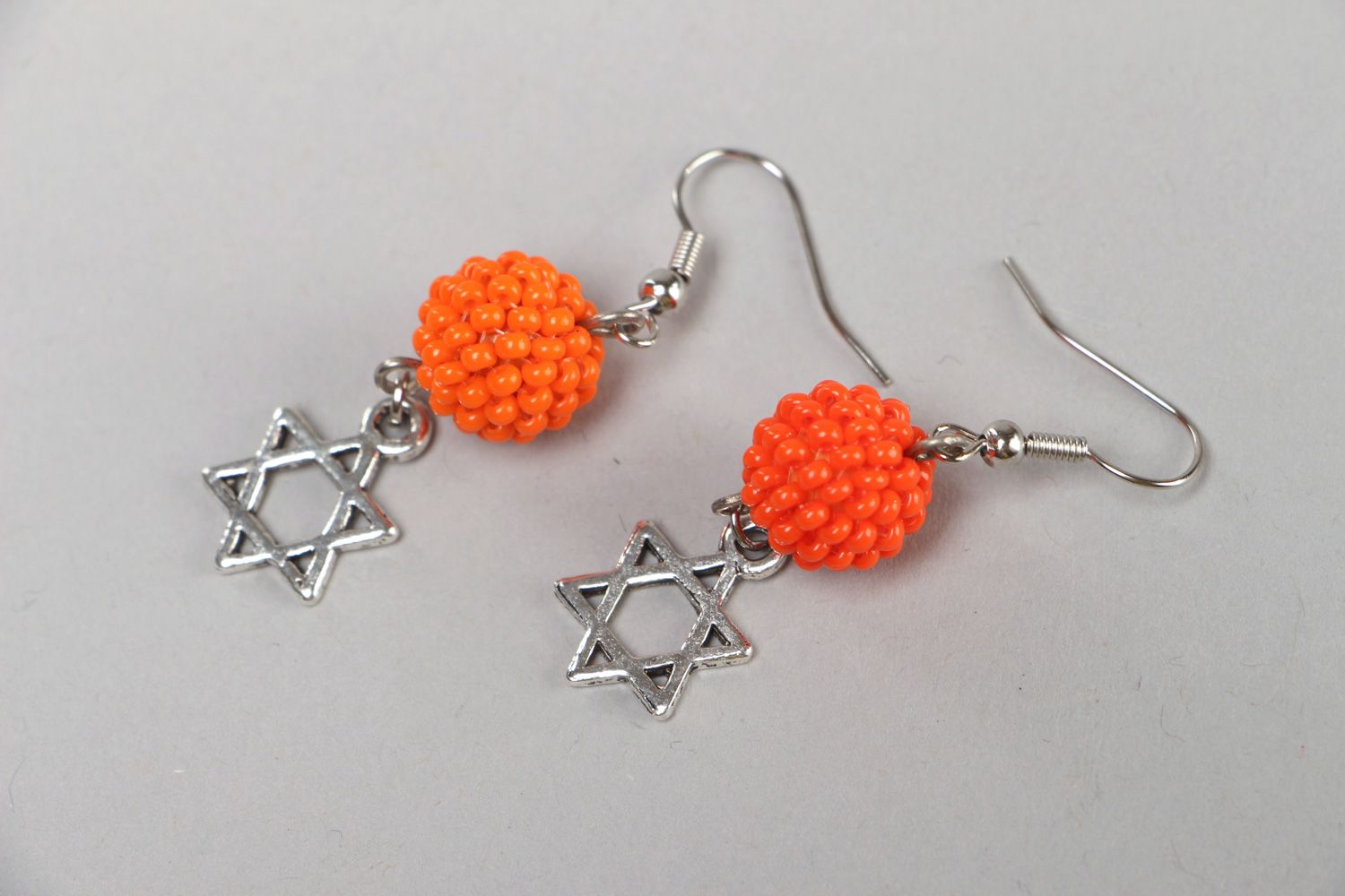Orangenfarbige handgemachte Ohrringe aus Glasperlen mit Anhängern aus Metall Davidstern foto 1