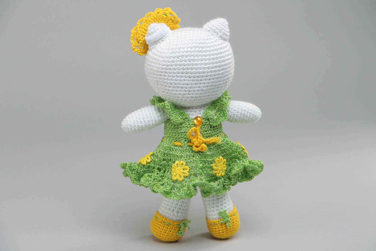 Soft handmade decorative crocheted toy cat in a green dress made of acrylic threads photo 4