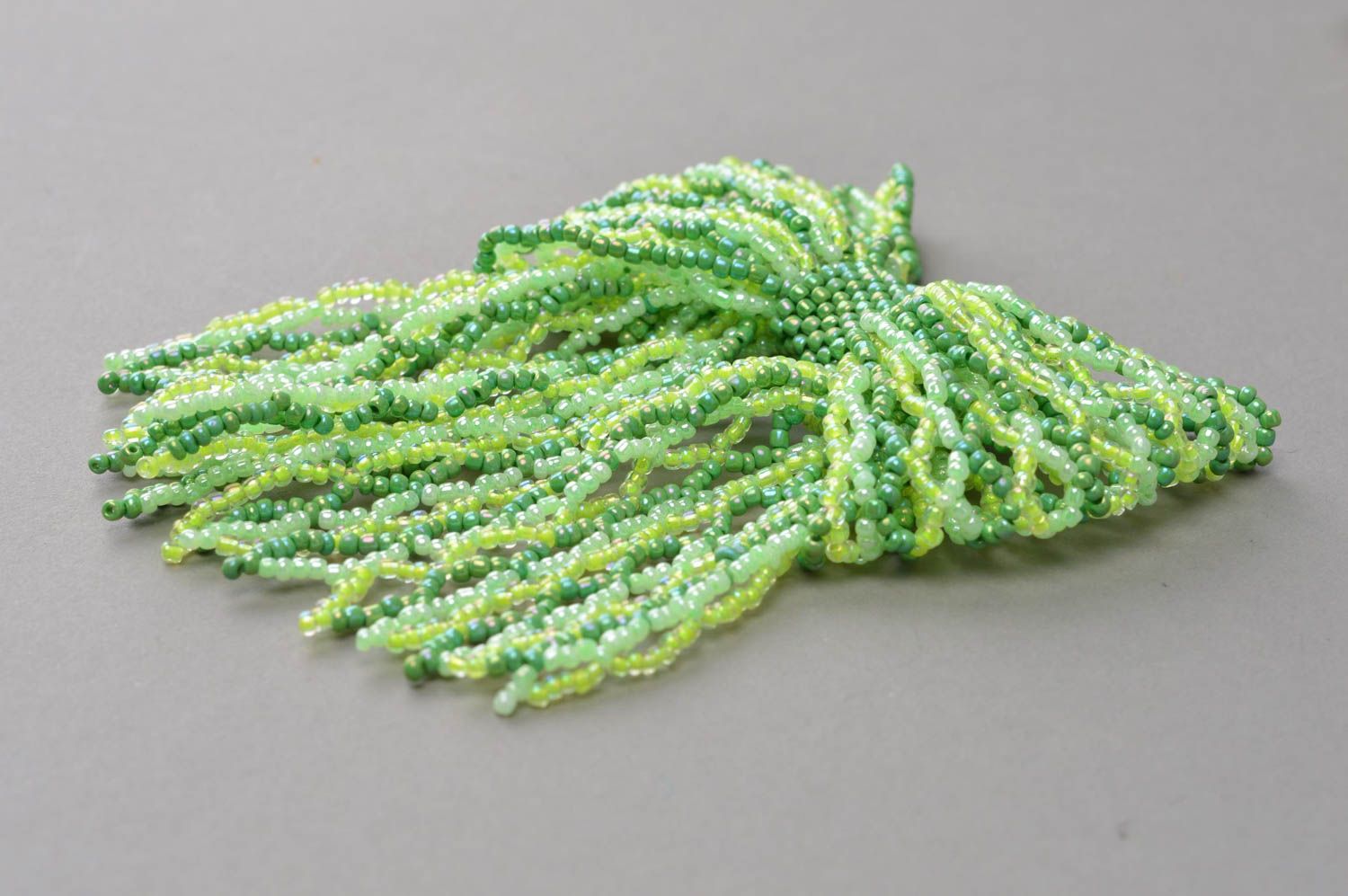 Брошь из бисера плетеная ручной работы авторская зеленая в виде бантика фото 3