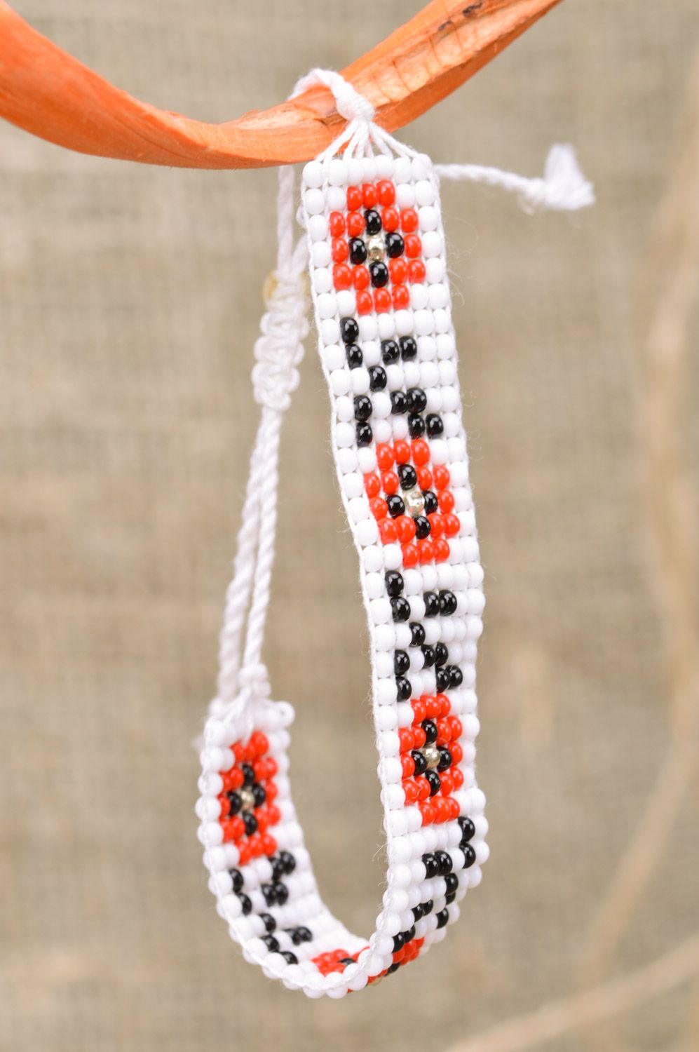 Handmade wrist bracelet woven of black white and red beads with ethnic ornament photo 1